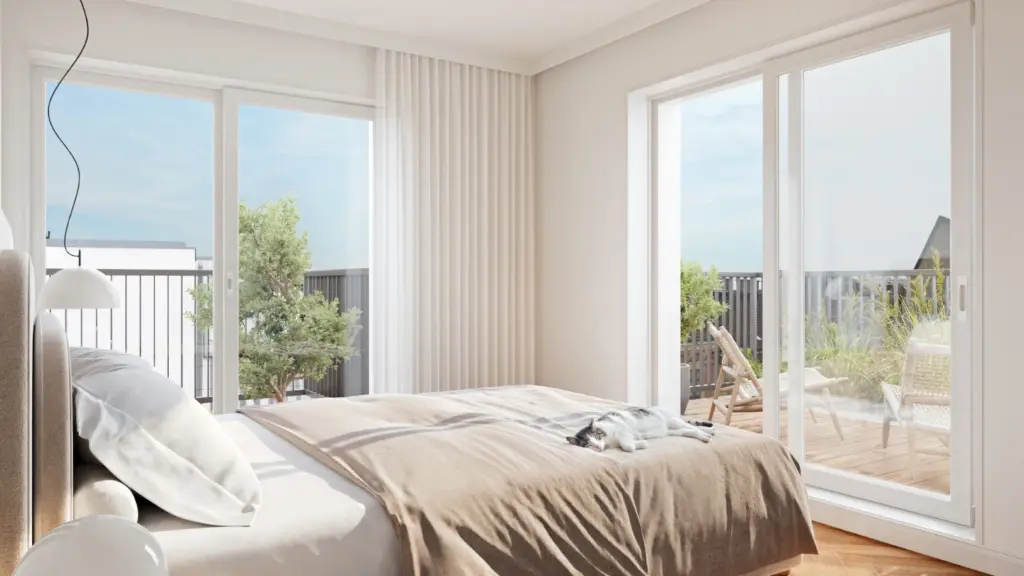 Helles Schlafzimmer mit Zugang zur begrünten Terrasse, Katze liegt auf dem Bett.